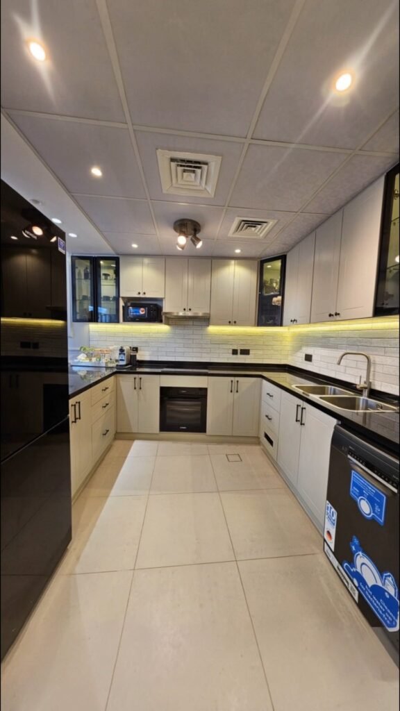 Motor City apartment kitchen after renovation - finished white custom cabinetry